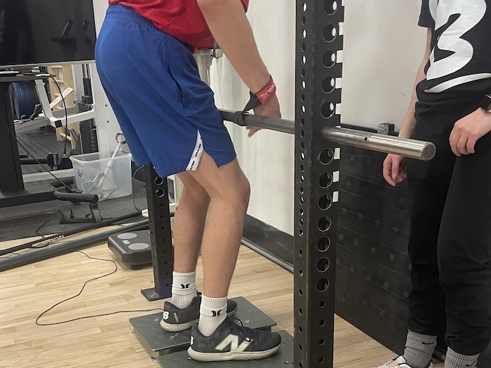 An athlete is preparing to lift a horizontal bar.