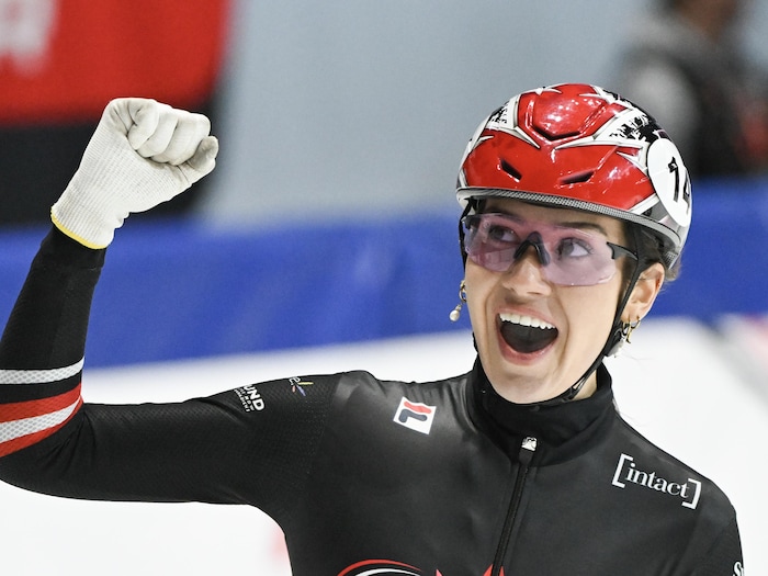 Elle lève le poing en célébration.