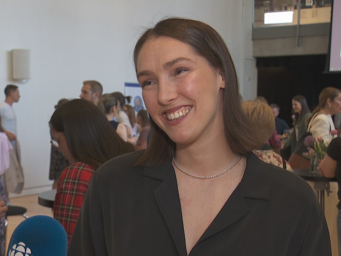 Elle sourit pendant qu'elle répond à des questions au micro pendant une soirée.
