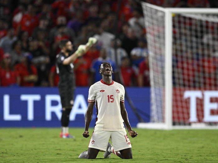 Il est à genoux sur le terrain et crie pour célébrer la victoire.