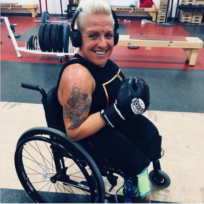 Une femme handicapée présente fièrement un gant de boxe.