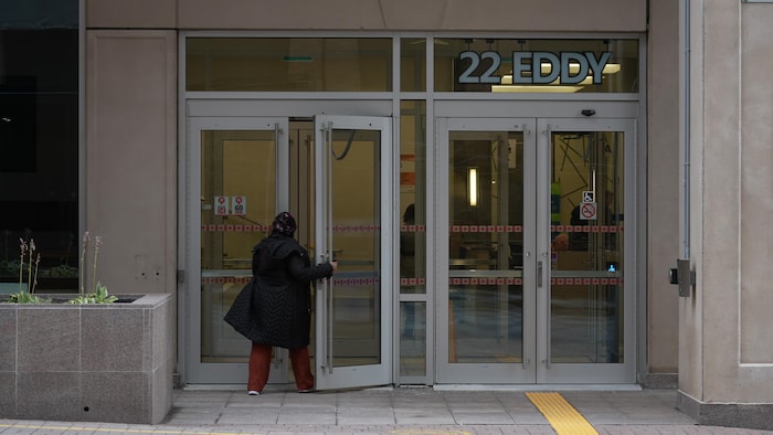 Une femme entrant dans un édifice fédéral.