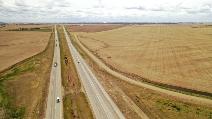 Un champ et l'autoroute 11, au nord de Regina, en Saskatchewan, au printemps 2022.