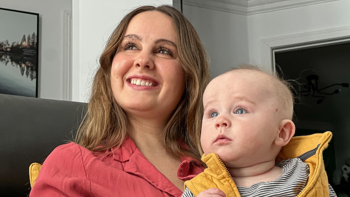 La mère et son poupons assis sur un divan.