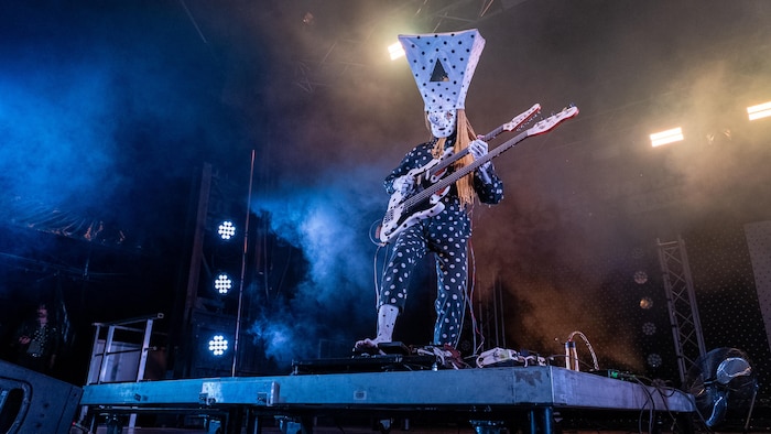 Le bassiste du groupe est sur scène.