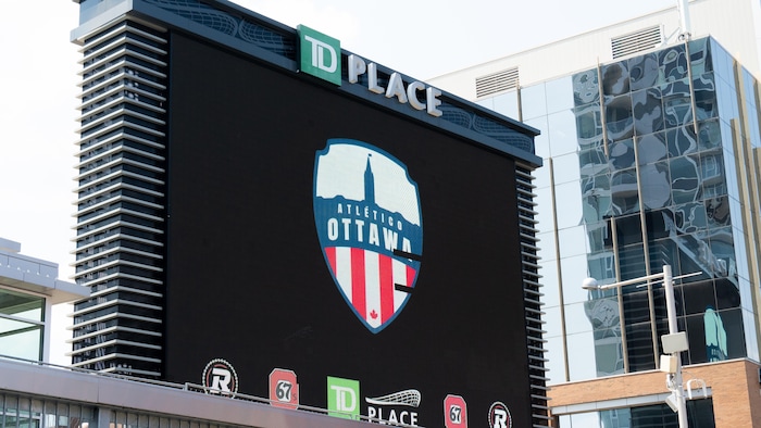 Un panneau devant un immeuble indiquant Atlético Ottawa.