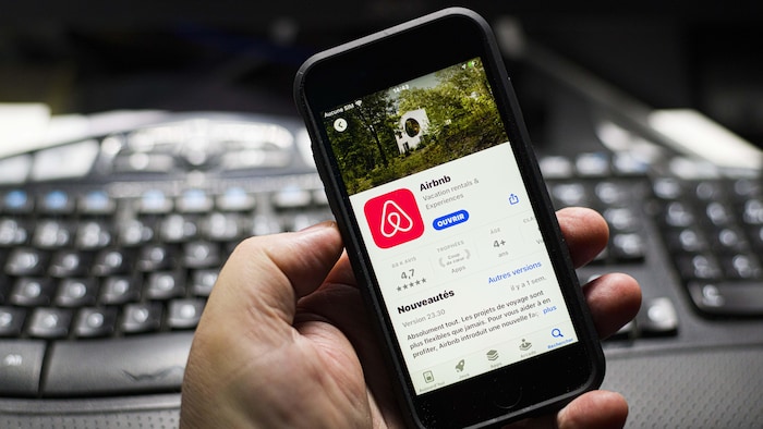 Un téléphone intelligent sur lequel on voit l'application d'Airbnb.