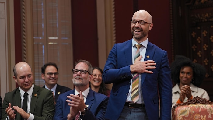 Sol Zanetti, souriant, porte sa main droite sur sa poitrine.