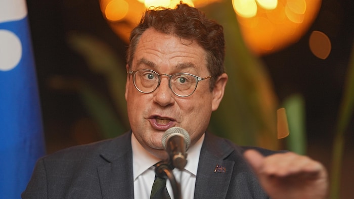 Bernard Drainville devant un micro.