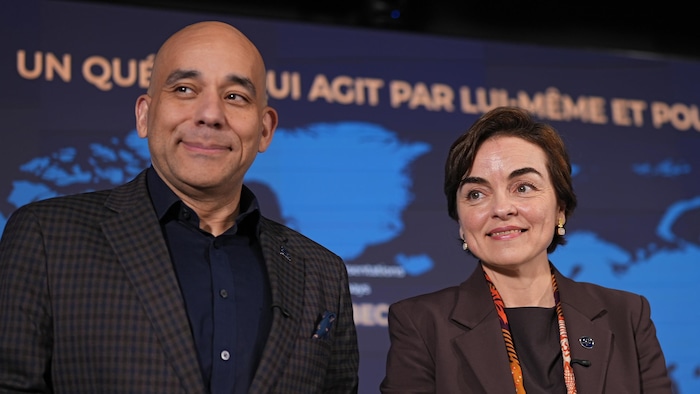 M. Skeete et Mme Fréchette devant une carte du monde.