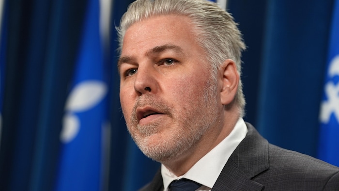 Pascal Bérubé devant des drapeaux du Québec.
