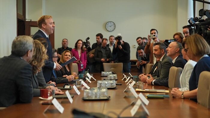 Des députés sont assis autour d'une vaste table que préside le ministre Mathieu Lévesque.