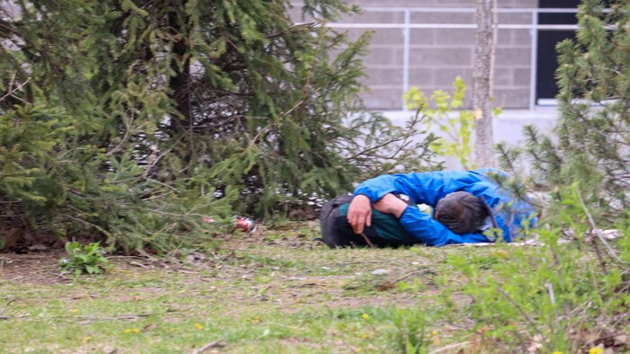 Un homme dort sur le sol près de Lauberivière.