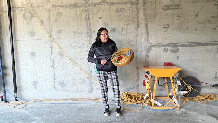 Une femme joue du tambour.