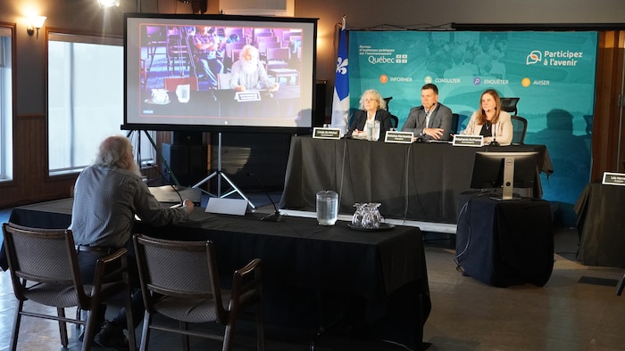 Des personnes assises qui discutent dans une salle.