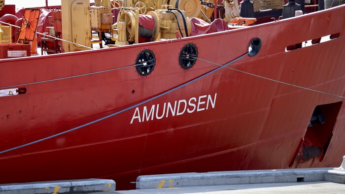 Gros plan d'un navire brise-glace rouge portant le nom de NGCC Amundsen.