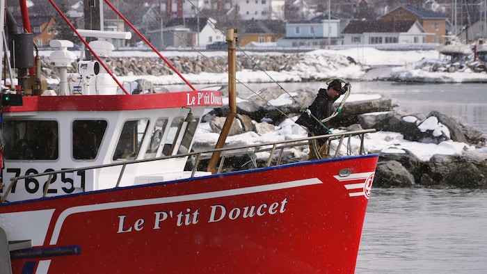 Un pêcheur s'apprête à lancer une amarre.