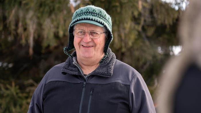 Portrait de Pierre-Paul Langlois, un sexagénaire souriant portant une tuque de laine verte à motif.