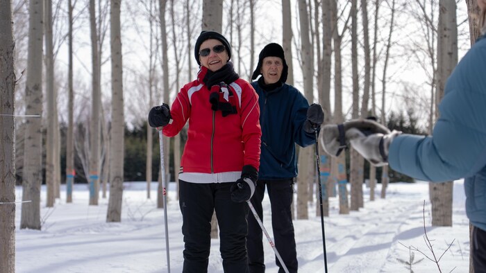 Deux personnes aînées souriantes en ski de fond.