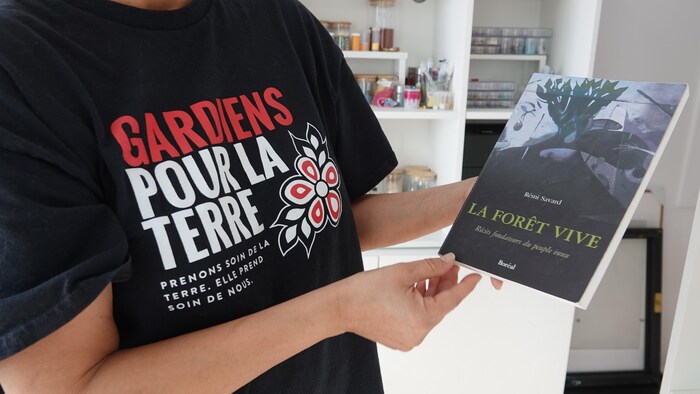 Michèle Audette montre le livre « La forêt vive » de Rémi Savard.