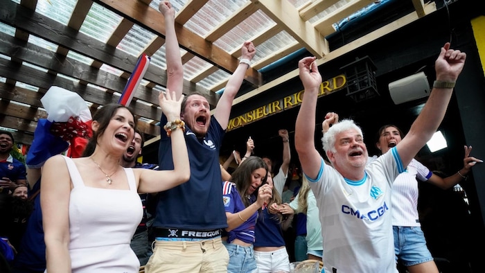 Des personnes crient et lèvent les bras en signe de joie dans le bar Monsieur Ricard.