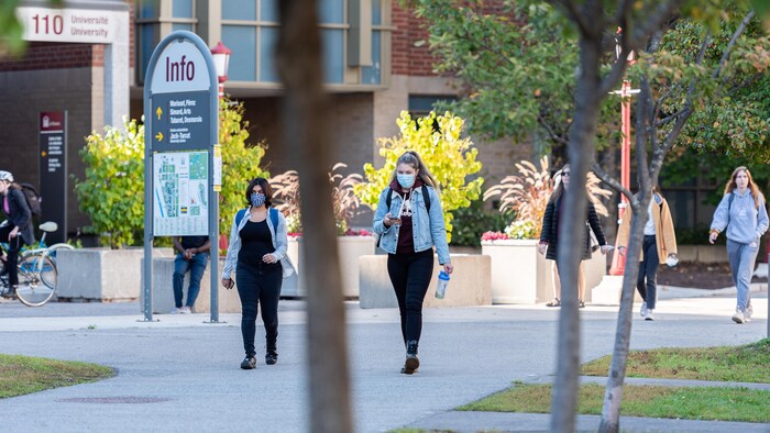 Des jeunes masqués marchent sur le campus de l'Université d'Ottawa.