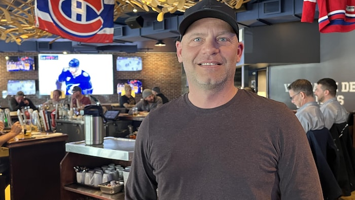 Portrait d'un homme dans un restaurant avec des décorations des Canadiens de Montréal. 