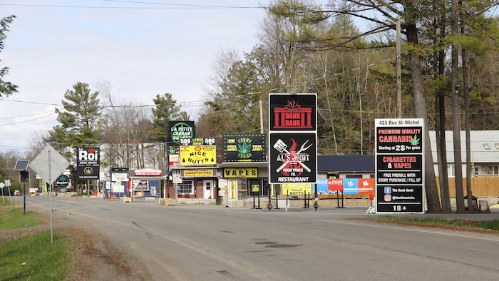 Des panneaux au bord de la route indiquant des magasins de cannabis. 