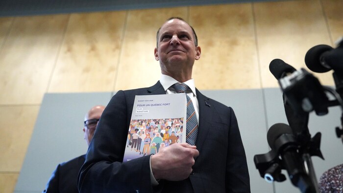 Eric Girard tient lad papers budgétaire.