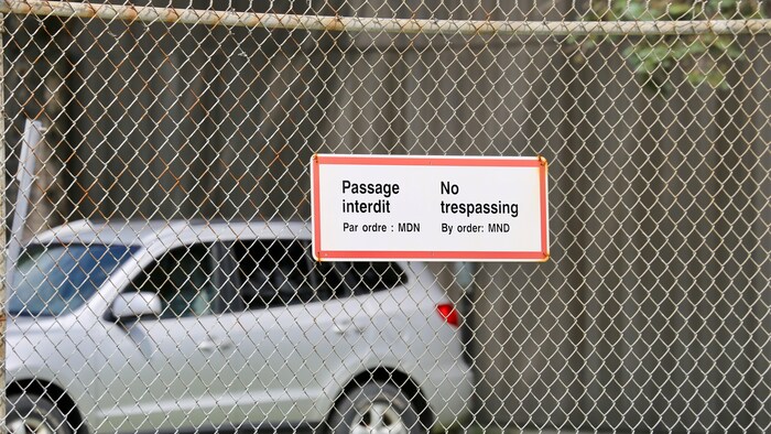 Une affiche sur laquelle il est écrit Passage interdit, installée sur une clôture.