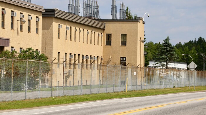 Une clôture de barbelés est installée devant le bâtiment du Centre de recherches à Valcartier, le long de la route de la Bravoure.