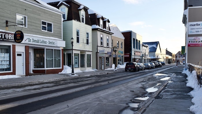 Une rue au coeur d'une petite ville avec des commerces de chaque côté.