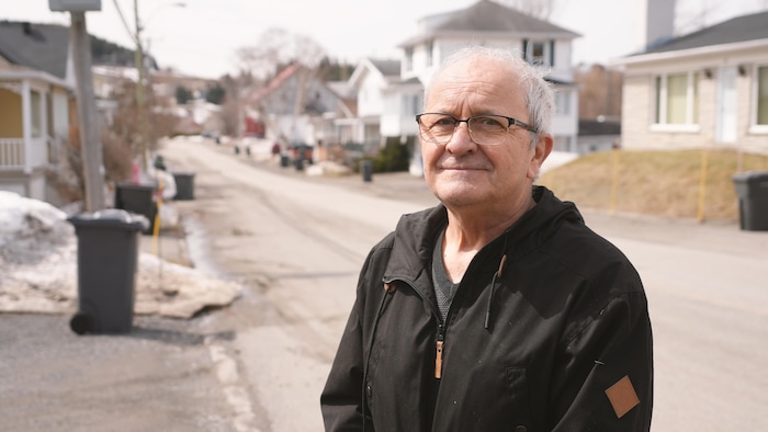 Une photo de Charles Lavoie, près d'une rue de sa communauté.