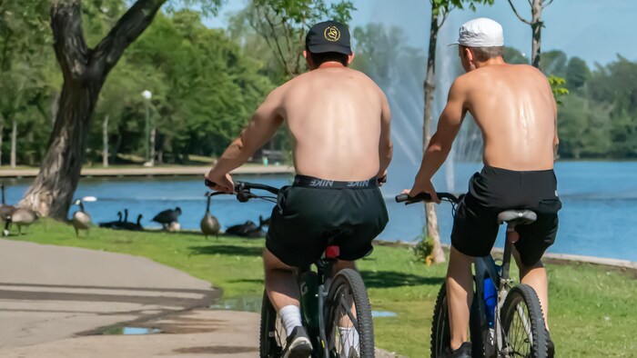 Deux cyclistes dans le parc Wascana de Regina, en Saskatchewan, lors d'une canicule à l'été 2022.
