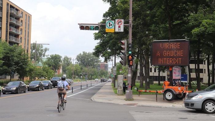 Une cycliste circule sur un corridor réservé aux vélos aménagé le long du chemin Sainte-Foy.