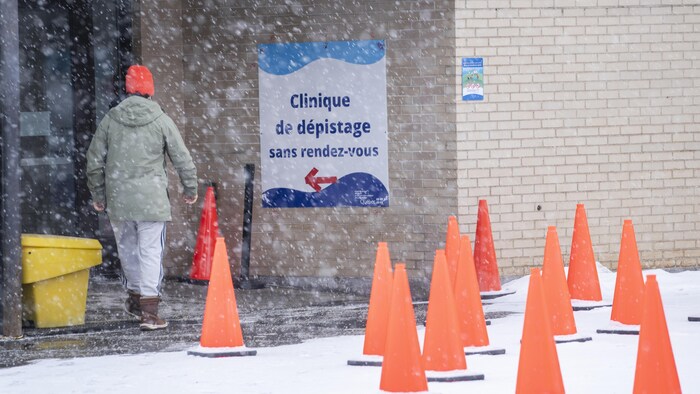 Une personne s'apprête à entrer dans une clinique de dépistage de la COVID-19.
