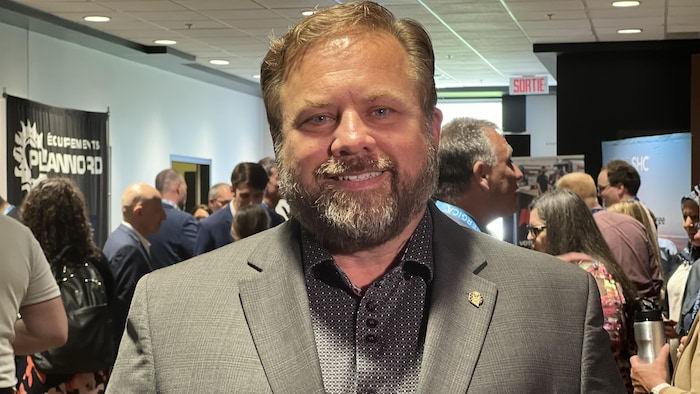 Portrait de l'homme âgé d'une soixantaine d'années lors d'un rassemblement public.