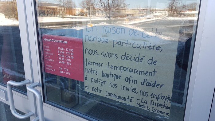 Une affiche sur la porte d'une boutique qui explique pourquoi c'est fermé
