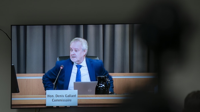Le commissaire Gallant, vu sur un écran d'ordinateur posé sur un bureau.