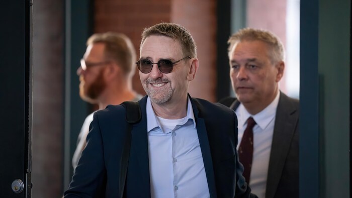 Karl Malenfant, souriant, dans un corridor de l’édifice Andrée-P.-Boucher.