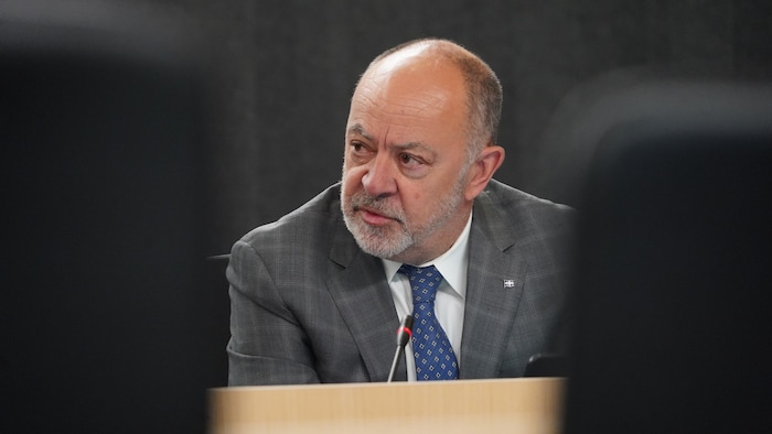 Le ministre Christian Dubé, derrière un micro.