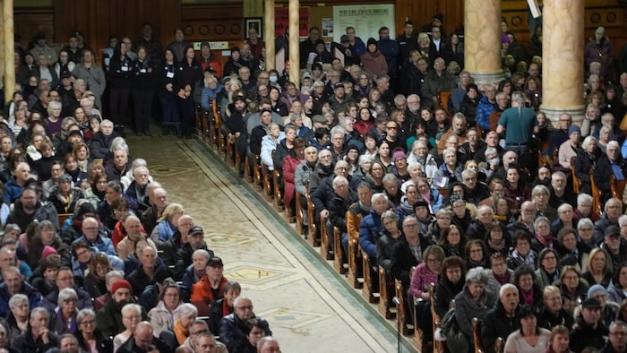 Des centaines de personnes assises dans une église