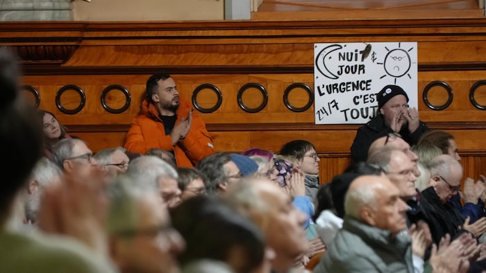 Des gens assis avec des pancartes.