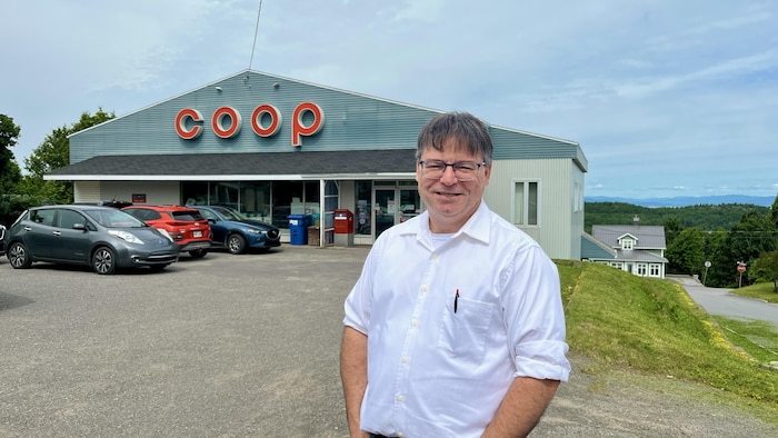 Janin Lévesque est debout devant le bâtiment de la coop. 