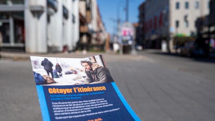 Feuillet sur l'itinérance à Trois-Rivières, avec le centre-ville en arrière-plan.