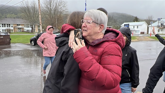 Une dame qui fait un câlin à une jeune fille.