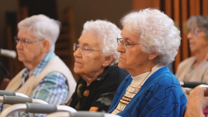 Des femmes âgées à l'écoute.