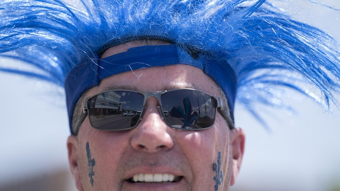 A man wears a blue wig. In addition, saint-jean-baptiste: montreal fleurdelisé overwhelming heat saint-jean-baptiste: montreal fleurdelisé overwhelming heat new