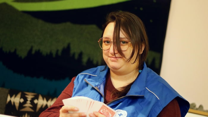 Morgana Lefebvre sourit en brassant des cartes. 