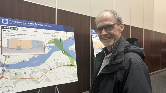 Un homme se tient devant un lutrin montrant les différents corridor pour le projet.